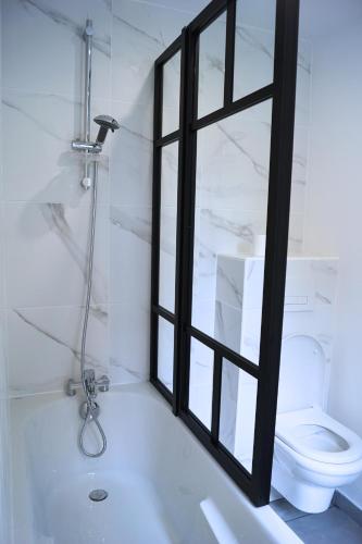 une salle de bain avec baignoire et toilettes et une fenêtre dans l'établissement Bel appartement Antony, 8min RER B à pied, proche Paris et Orly, à Antony