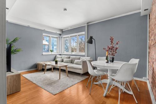 uma sala de estar com um sofá branco e uma mesa em Charming and cozy - 5 min to city center - 5 pers em Oslo