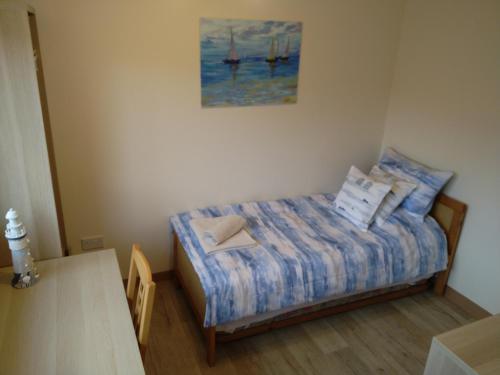 um pequeno quarto com uma cama e um quadro na parede em Beautiful 3-Bed Bungalow Kessingland rural retreat em Lowestoft