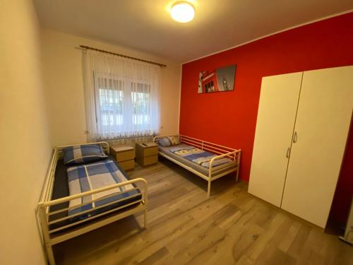 a room with two bunk beds and a red wall at Wohnung für bis zu 4 Personen in Ludwigshafen am Rhein