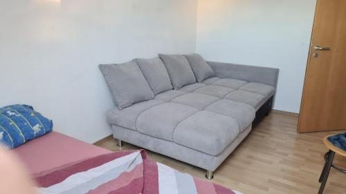 Guest house في لودفيغسهافن أم راين: أريكة رمادية في غرفة المعيشة مع طاولة