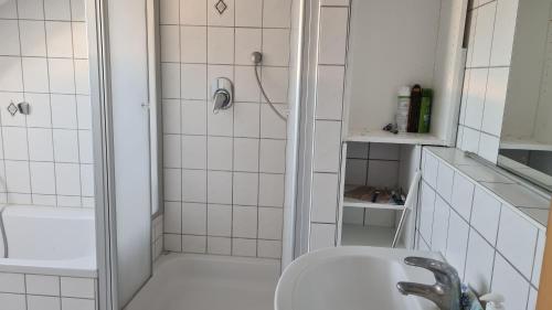 een witte badkamer met een wastafel en een douche bij Guest house in Ludwigshafen am Rhein
