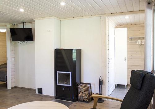 a living room with a fireplace and a tv at Särkisalon Villa Albin in Särkisalo