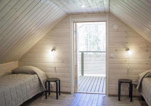 a room with two beds and a window in a attic at Särkisalon Villa Albin in Särkisalo