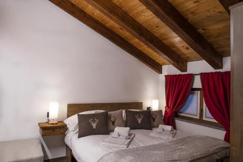 a bedroom with a bed with red curtains at Lo Stambecco Bianco Chalet in Aosta