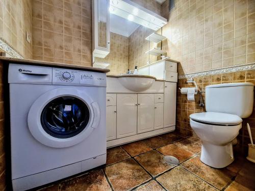 een badkamer met een wasmachine, een toilet en een wastafel bij Beach panorama Caleta in Caleta De Velez