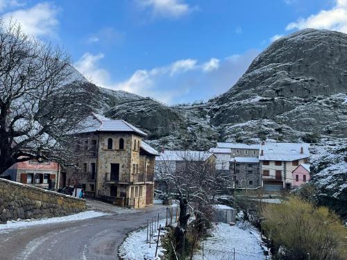 a village on a snowy road with a mountain in the background at Moradas Portilla in Portilla de la Reina