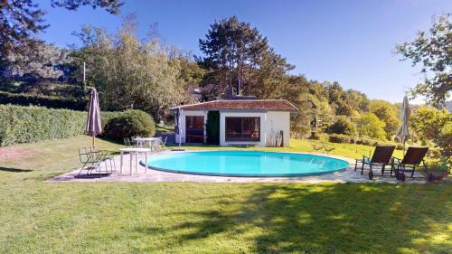 einen Pool in einem Garten mit Stühlen und einem Haus in der Unterkunft Sy - Les Aywisses in Ferrières