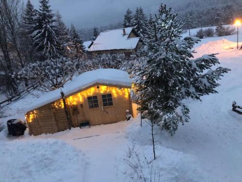 a cabin covered in snow with lights on it at La Boissette d’en O in Montgenèvre