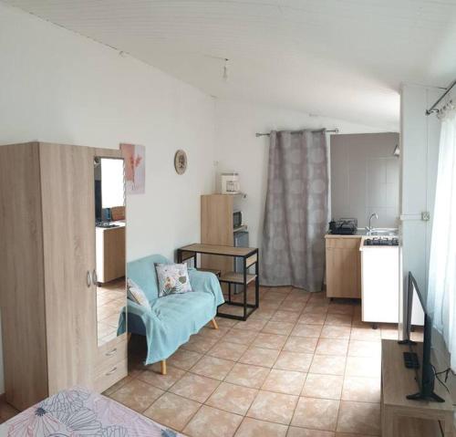 ein Wohnzimmer mit einem Sofa und einer Küche in der Unterkunft Ti Caz Emma in La Possession