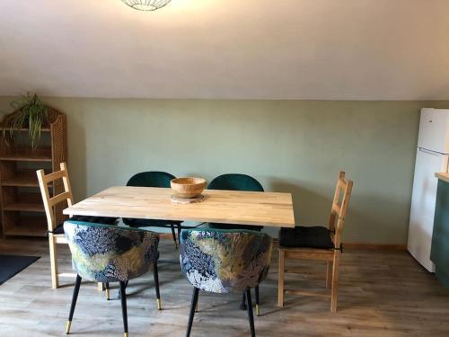 a dining room table with chairs and a wooden table at La Boissette d’en O in Montgenèvre