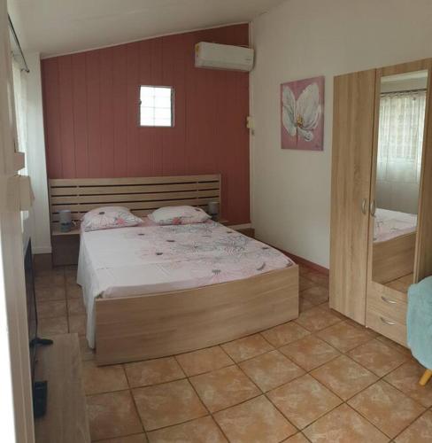 ein Schlafzimmer mit einem großen Bett in einem Zimmer in der Unterkunft Ti Caz Emma in La Possession
