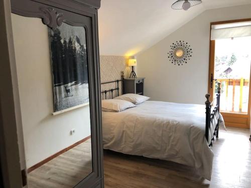 a bedroom with a bed and a mirror at La Boissette d’en O in Montgenèvre