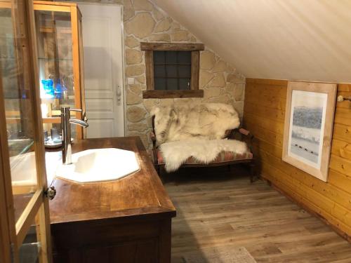 a bathroom with a sink and a couch in a room at La Boissette d’en O in Montgenèvre