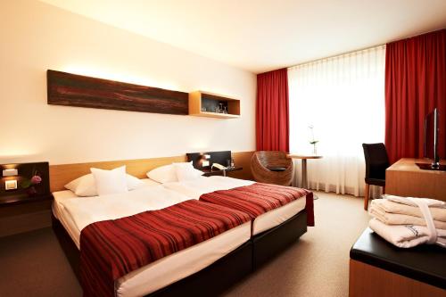 a hotel room with a large bed in a room at Hotel Zugbrücke Grenzau GmbH in Höhr-Grenzhausen