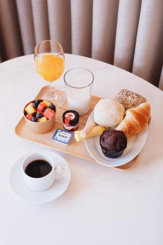 un vassoio con prodotti per la colazione e un bicchiere di succo d'arancia di ORM Padrão Apartment a Porto