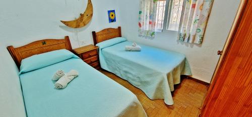 um quarto com 2 camas e toalhas em VeLEZ NAZARI CORTIJO LEON em Motril