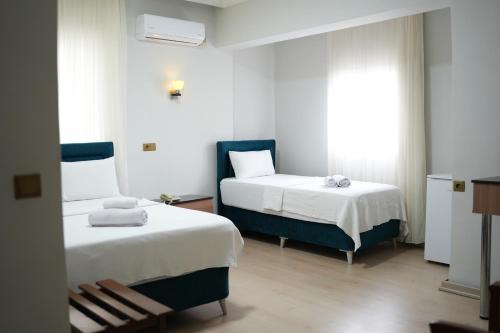 a bedroom with two beds and a window at Grand Clover Otel in Seyhan
