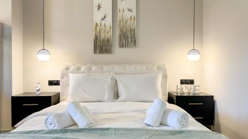 a bedroom with a white bed with two night stands at Tsikaris Boutique Guesthouse in Kalabaka