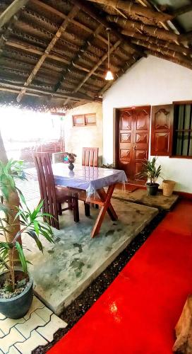 a dining room with a table and chairs on a red carpet at Venora Hiriketiya in Dickwella