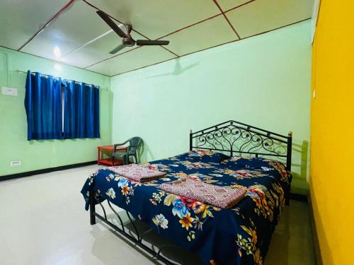 a bedroom with a bed with a quilt on it at Krupasagar Homestay in Malvan
