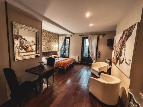 リモージュにあるVILLA FLEURY - APPART'HÔTEL DE STANDINGのベッド、テーブル、椅子が備わるホテルルームです。