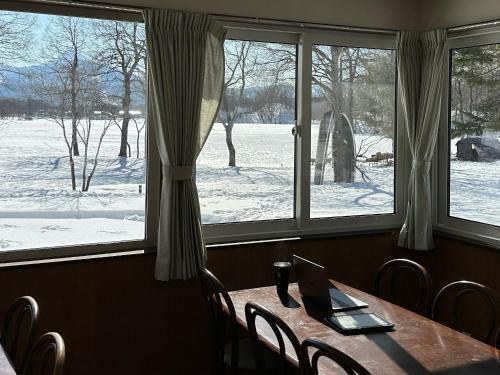 a table with a laptop on it in front of a window at Lakeside Hotels Kuore in Kitashiobara
