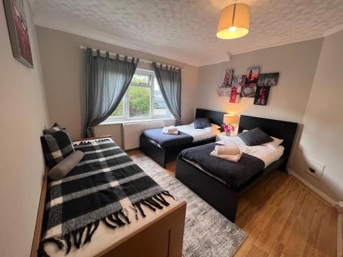 uma sala de estar com duas camas e um sofá em Croydon apartment with parking em Londres