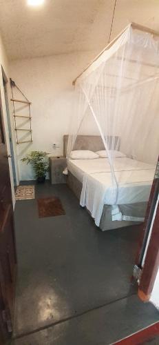 a bedroom with a bed with a mosquito net at Venora Hiriketiya in Dickwella
