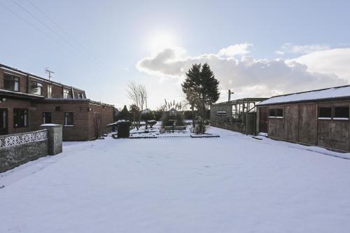a yard covered in snow next to some buildings at The Amethyst Hotel - Full House in Immingham
