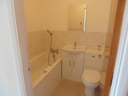 a bathroom with a sink and a toilet and a bath tub at The Amethyst Hotel - Full House in Immingham