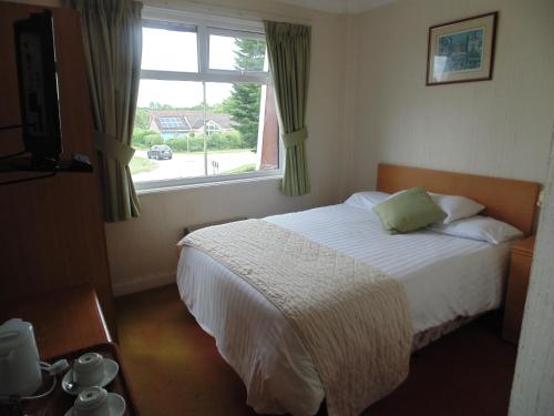 a bedroom with a white bed and a window at The Amethyst Hotel - Full House in Immingham