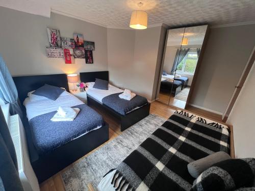 a bedroom with two beds and a mirror at Croydon apartment with parking in London