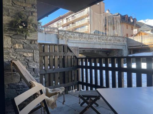 pies siedzący na krześle na balkonie w obiekcie Chalets Patchwork w mieście Valloire
