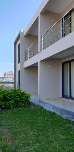 a white apartment building with a lawn in front of it at ANILLAH APPARTMENTS in Centre de Flacq