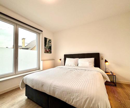 a bedroom with a large bed and a large window at Il Casolare in Beersel