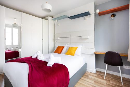 a bedroom with a white bed and a black chair at Stunning 1-bedroom apartment in a vibrant neighborhood of Montmartre in Paris