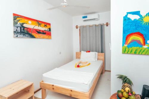 Habitación con cama y pintura en la pared en TIKI Beach Club & Resort, en Bwejuu