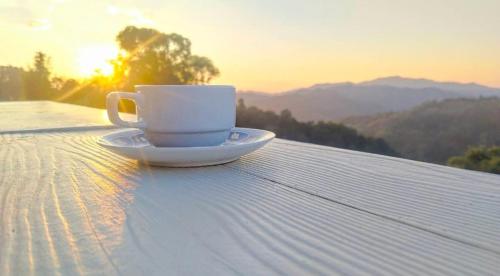 a cup of coffee sitting on top of a table at ดอยตุง สันติสุขโฮมสเตย์ in Ban Pa Kluai La Hu