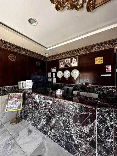 a lobby with a marble counter with clocks on the wall at اجنحة الازدهار للوحدات السكنية in Rafha