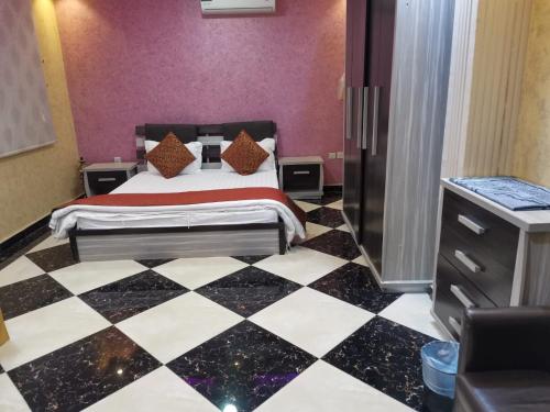 sypialnia z łóżkiem i szachownicą w obiekcie اجنحة الازدهار للوحدات السكنية w Rafhie