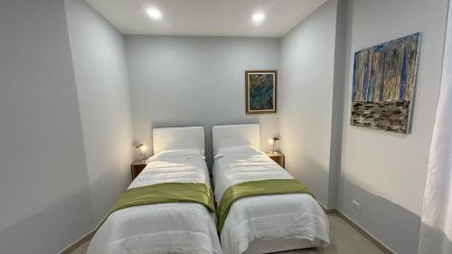 2 Betten in einem Zimmer mit weißen Wänden in der Unterkunft MATT59 APARTMENTS in Rho