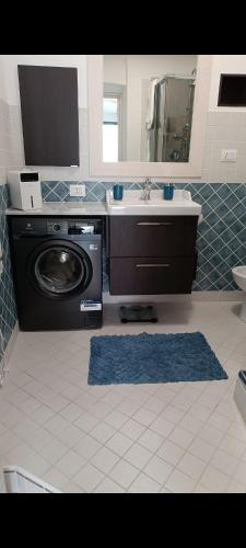 a bathroom with a sink and a washing machine at Villetta Fioregreco - free parking - Large outdoor space in Sanremo