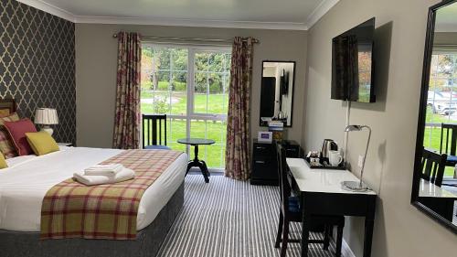 a hotel room with a bed and a desk and a window at Stone House Hotel ‘A Bespoke Hotel’ in Stone