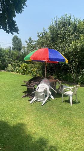 un groupe de chaises de jardin sous un parasol coloré dans l'établissement Zebervan Retreat, à Srinagar
