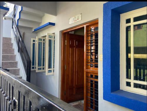 a house with a wooden door and stairs at The bluebird residence in Mysore