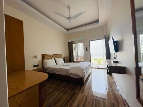a bedroom with a bed and a desk and a television at Dreamers Paradise in Jaliapāra