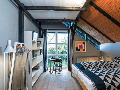 a bedroom with a bed and a window at Hyggeby - Architektenhaus mit Schleiblick, Sauna, etc in Ulsnis