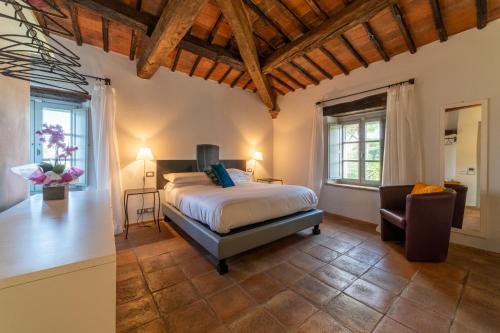 Locanda Della Picca في تشيتا ديلا بيفي: غرفة نوم بسرير وكرسي في غرفة