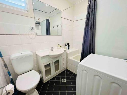 een witte badkamer met een toilet en een wastafel bij Opera & Harbour bridge view penthouse (3 rooms) in Sydney